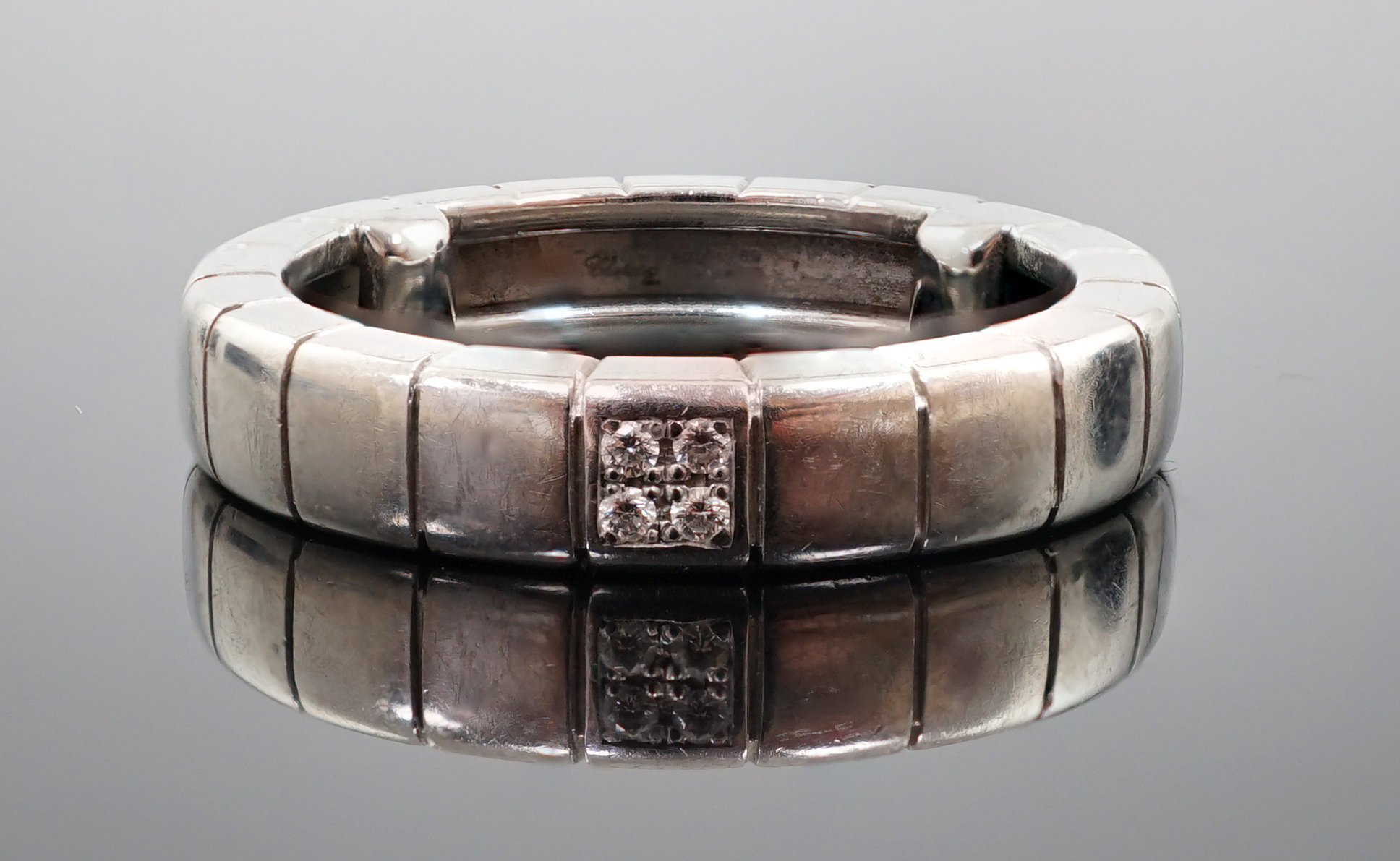 A modern Chopard 18ct white gold and four stone diamond chip cluster set band